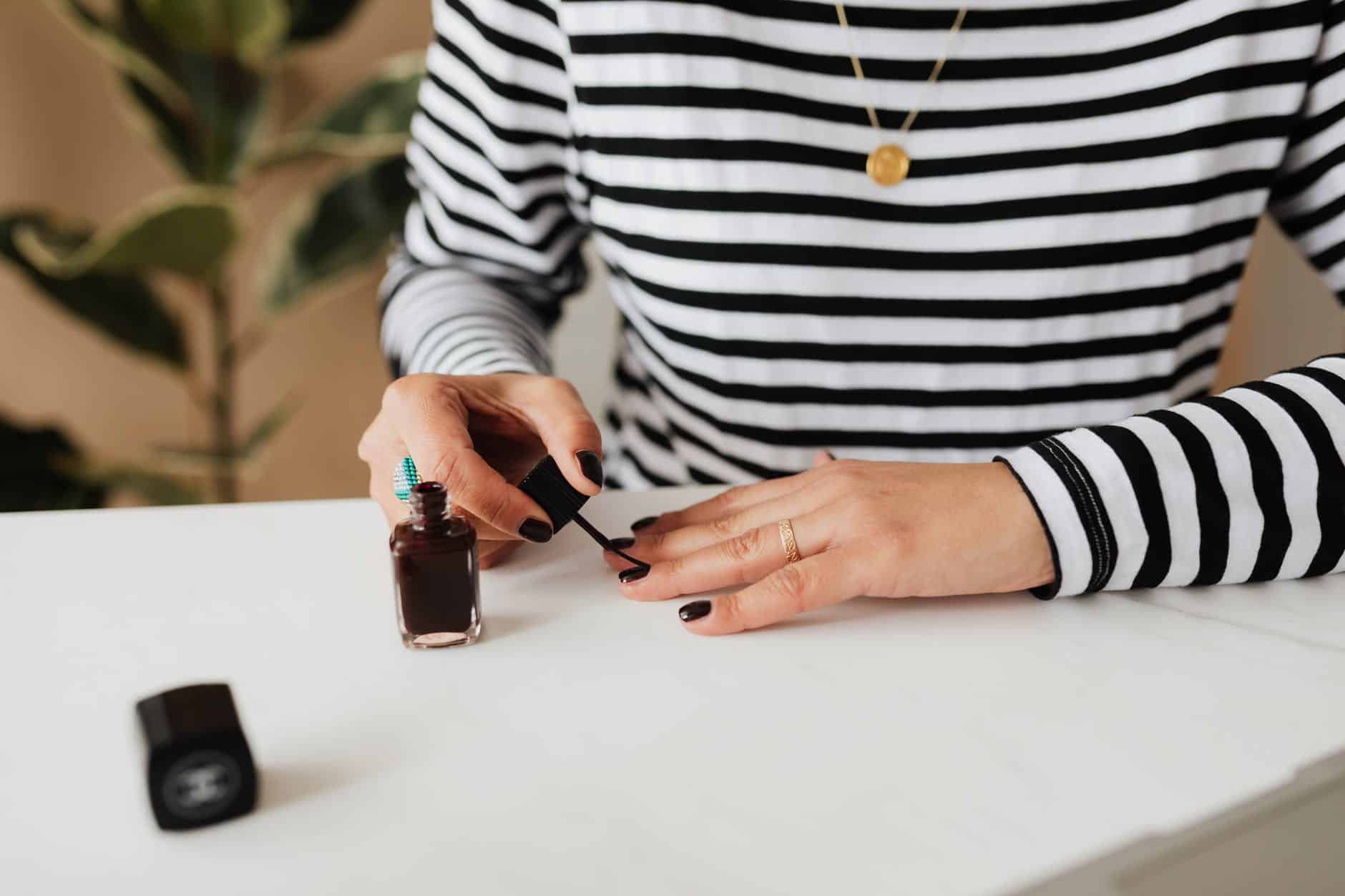 crop woman doing manicure at home